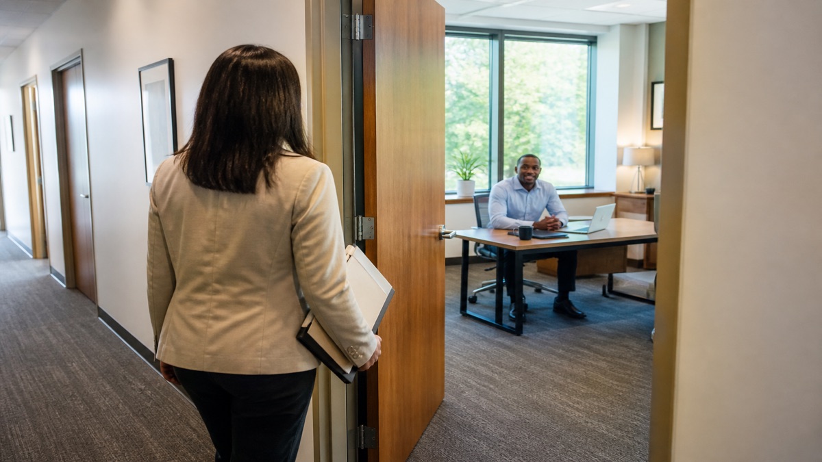 Employee returning to a manager office with a folder of notes