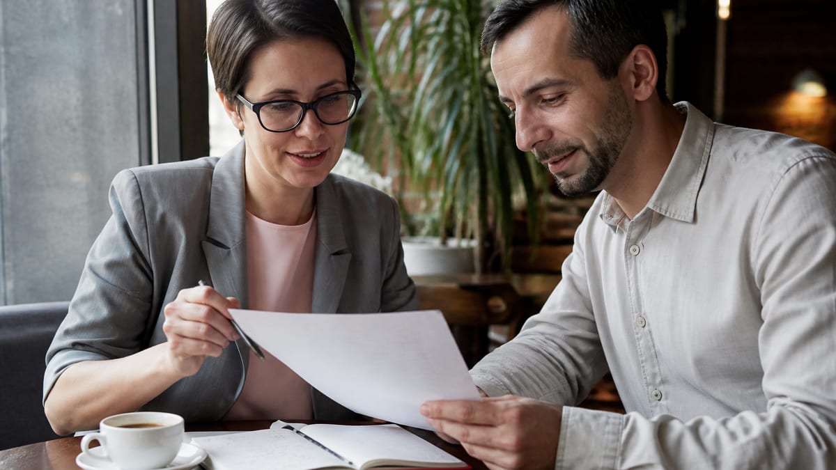 Writer and client reviewing a printed resume together at a cafe table