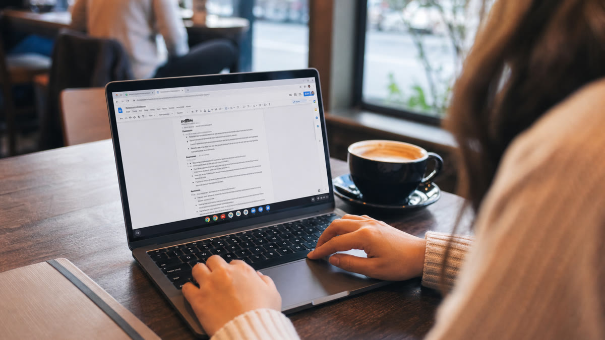 Job seeker building an ATS-friendly resume in Google Docs on a laptop with a printed checklist beside the keyboard